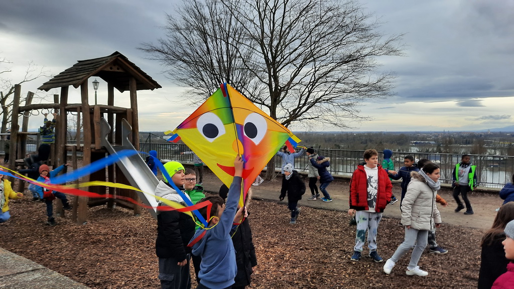 Kinder lassen Drachen auf dem Spielplatz steigen